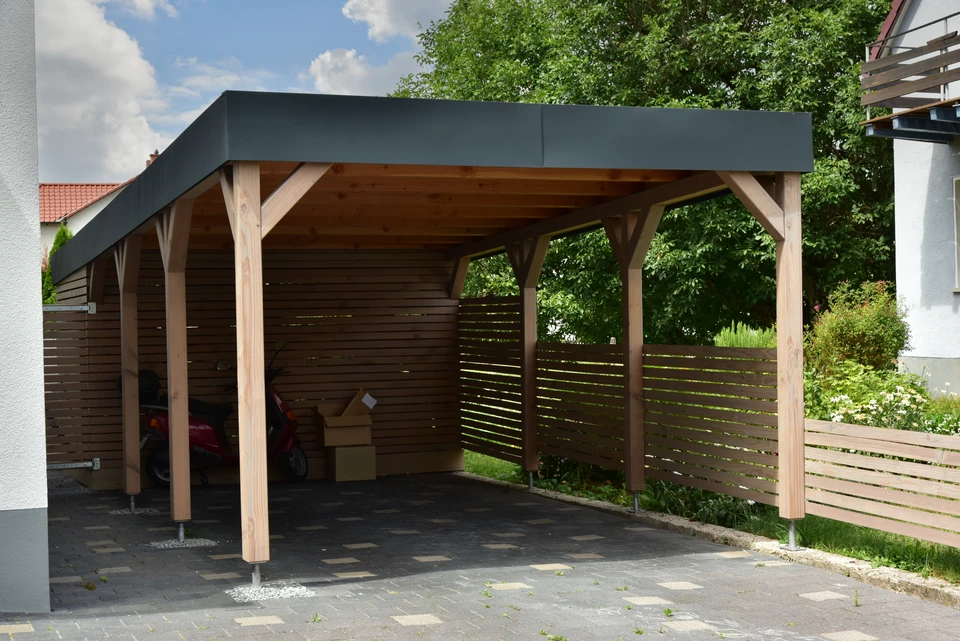 Chantier de construction d'une terrasse en bois sur pilotis avec structure de couverture en cours d'assemblage