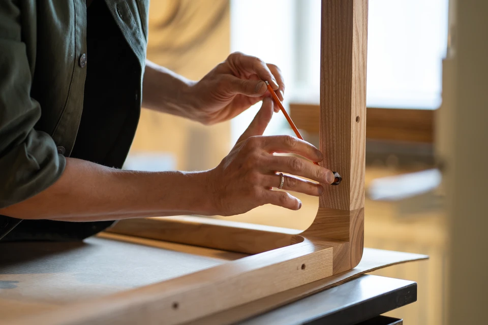 Artiste principal et apprenti charpentier avec un plan d'ensemble discutez d'un projet de construction de maison